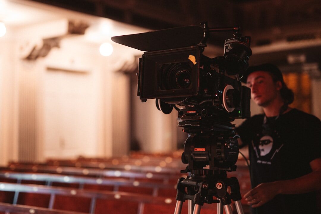 Technician installing a professional video camera on a tripod